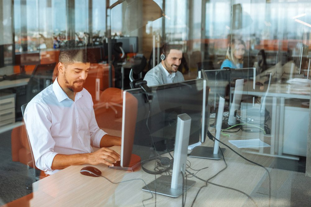 office with employees in front of computer