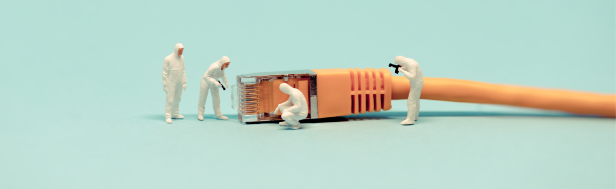 tiny toy workers examining ethernet cord 