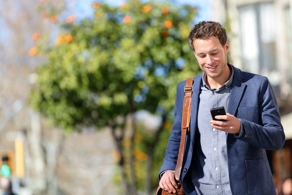 man walking checking cell phone